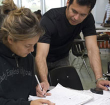 Teacher helping student at her desk