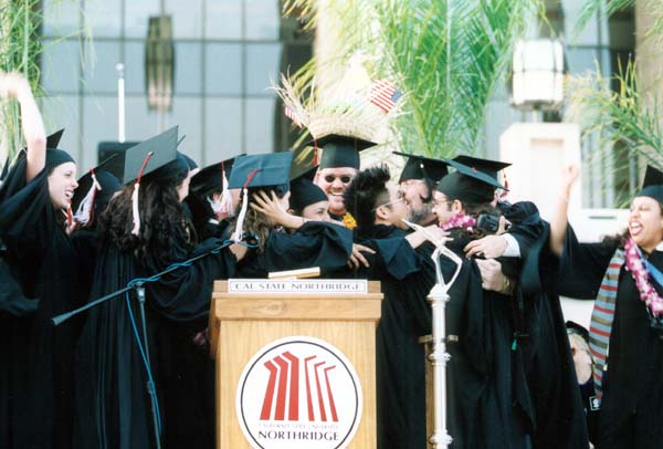 Crowd of graduates hugging