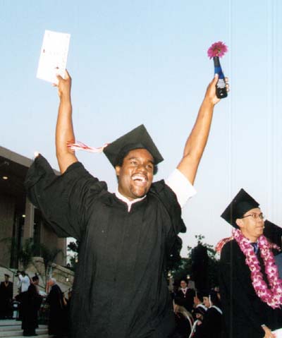 Male graduate celebrates with hands held high