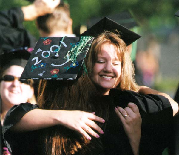 Two women graduates giving each other a big hug
