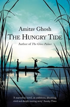 Cover of "The Hungry Tide" showing two people in a small boat silhouetted against sky and water.