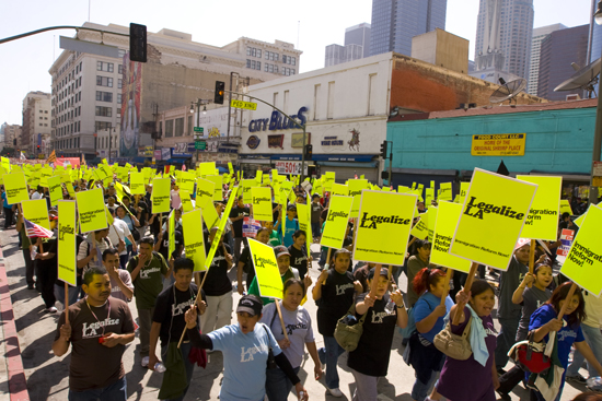 crowds of people with holding yellow signs reading Legalize LA