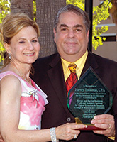 Mr. and Mrs. Bookstein holding the plaque awarded by the University.