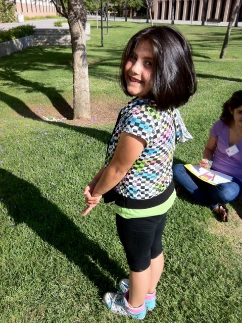 Child smiling over her shoulder