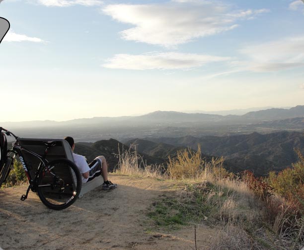 Alex sitting on the bench near the top of the mountain taking in nature and all its glory