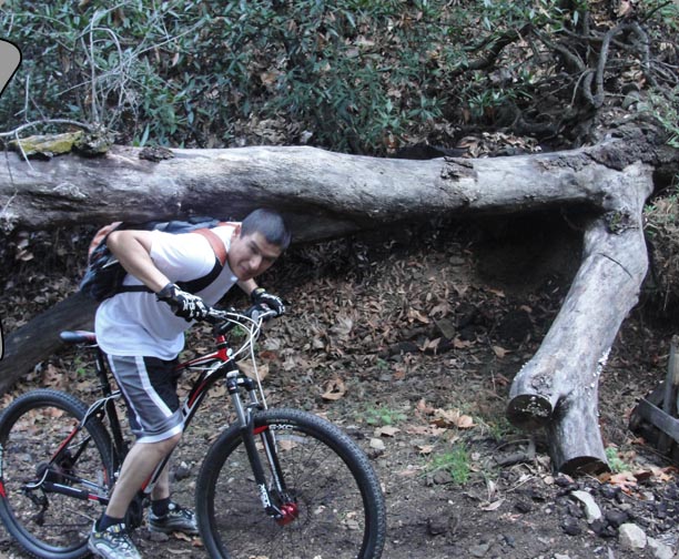 Alex under a tree on his Giant bike