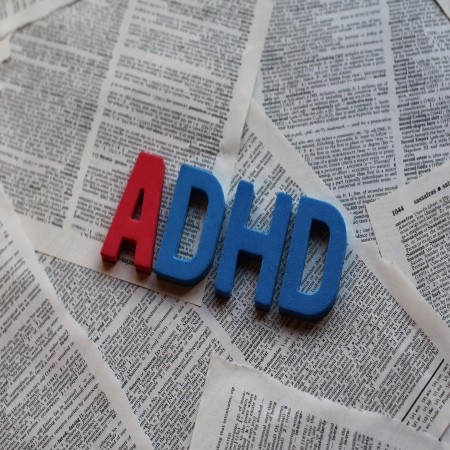 Letters ADHD over newspaper clippings