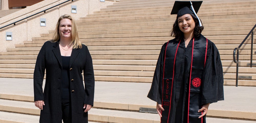 President Beck with a female student in Commencement robes.