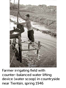 Farmer irrigating field with counter-balanced water lifting device (water scoop) in countryside near Tientsin, spring 1946 