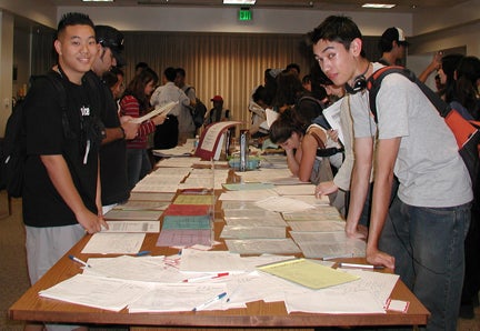 Students looking over hand out material at open house.