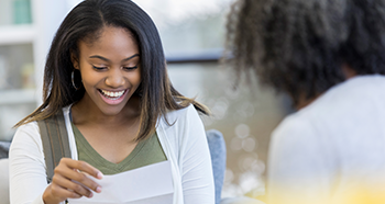 Students smiling and reading a letter.