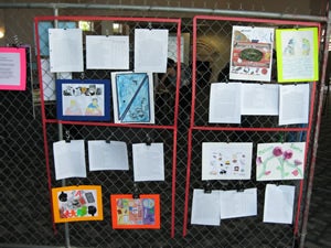 Various works presented on a fence wall