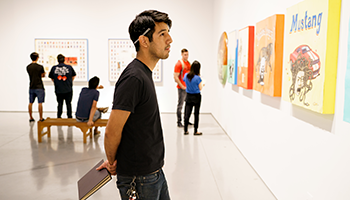 Male student looking at art work.