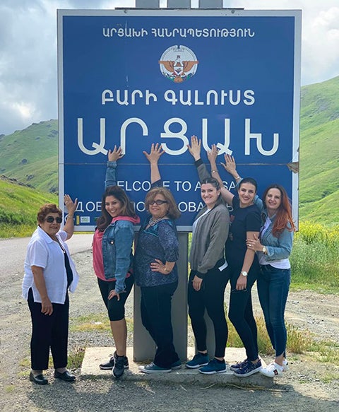 at the roadside, group gathers around armenian independence sign