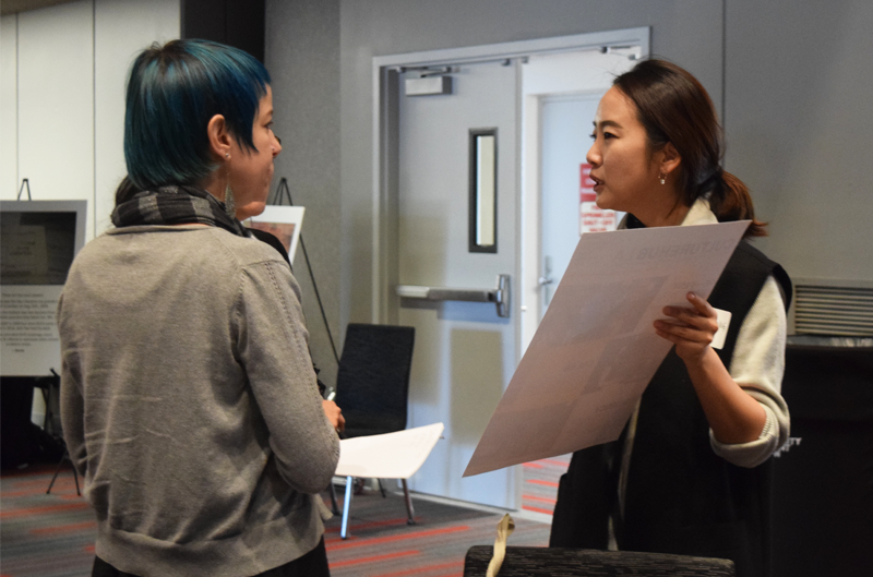 two female students talking at event