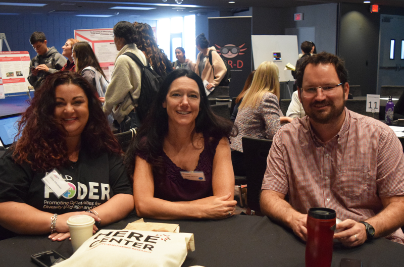 here center researchers at event table smiling