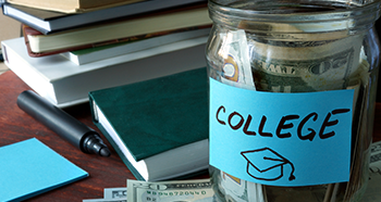 Jar labeled 'College' filled with money next to a stack of books.