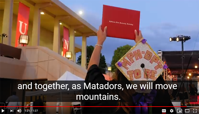 Student holds a diploma hardcover up in the air during CSUN commencement. Caption text "and together, as Matadors, we will move mountains"