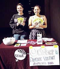 Two students at table for Domestic Violence Awareness Month