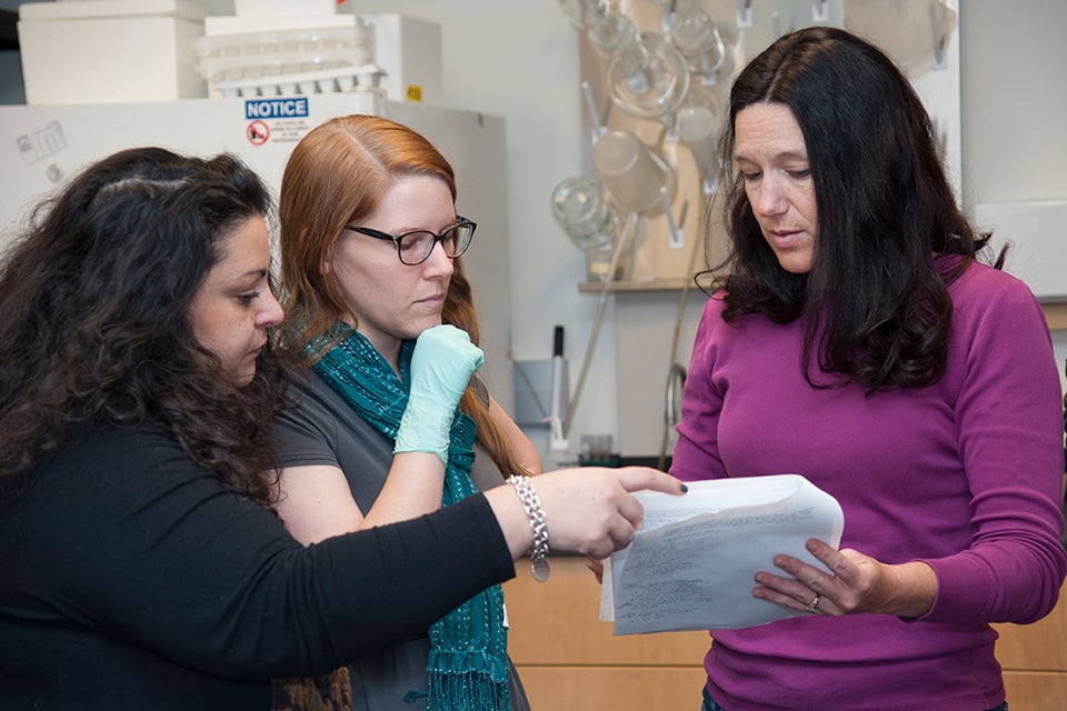 Biology professor Cindy Malone (right) discusses research in her lab. Malone uses humor to engage students and mentors them through her research lab and grant project. Photo by Nestor Garcia.