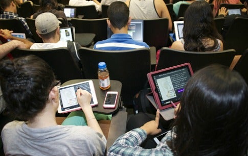 A photo showing students taking notes with their iPads during a class lecture.