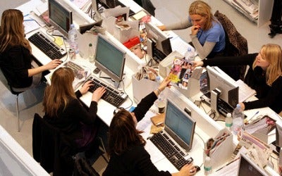 A photo showing employees working on their desktops in the office.