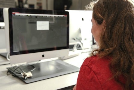 A photo of a female CSUN student using a desktop computer.