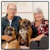 Photo of Richard and Ilona Buratti at home with their beloved boxer dogs, Travis (right) and Phoebe