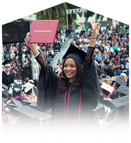 a student smiles and waves as she receives her diploma