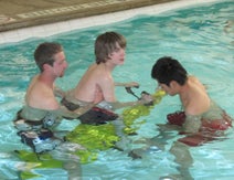 center of achievement staff assisting a young client in pool