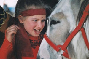 Kira Dimitri as a child next to a horse