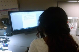 A woman at a computer using Office. 