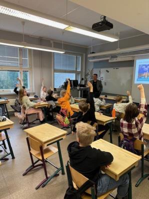 Conrad Ulpindo with students in a classroom in Helsinki