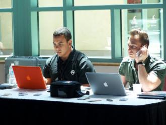 Men work behind their laptop computers.
