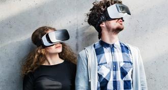 A woman and a man wearing VR headsets. 