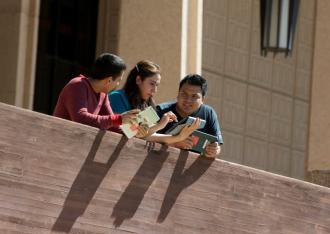 Students use iPads in front of library