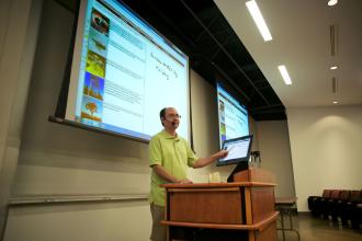 A professor standing in front of a classroom.