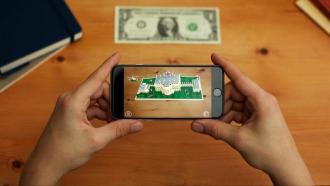 A person using a smartphone to view a dollar bill in augmented reality. 