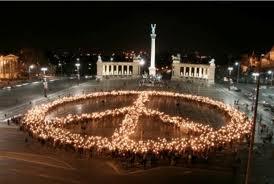 Peace symbol composed of people holding candles
