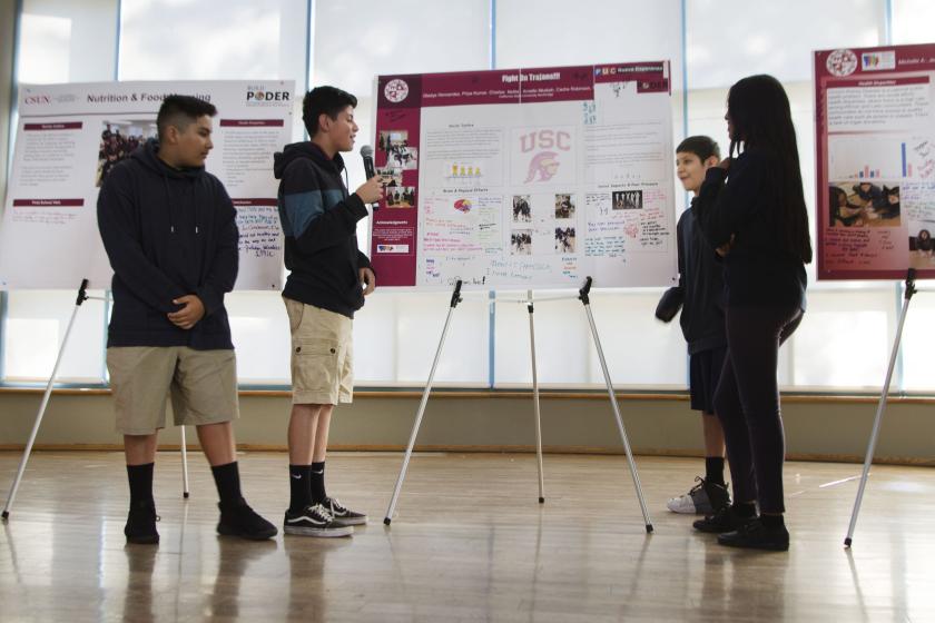 8th grade students give a poster presentation 