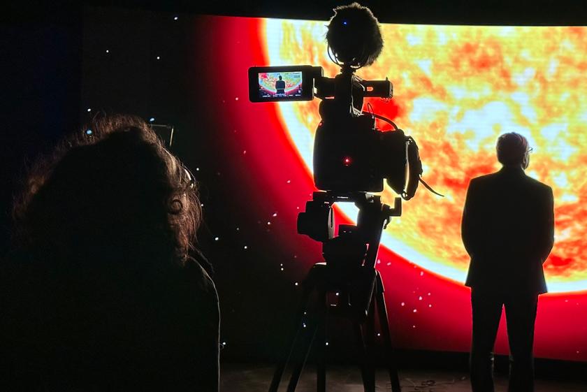 Film set with man on stage under an image of space