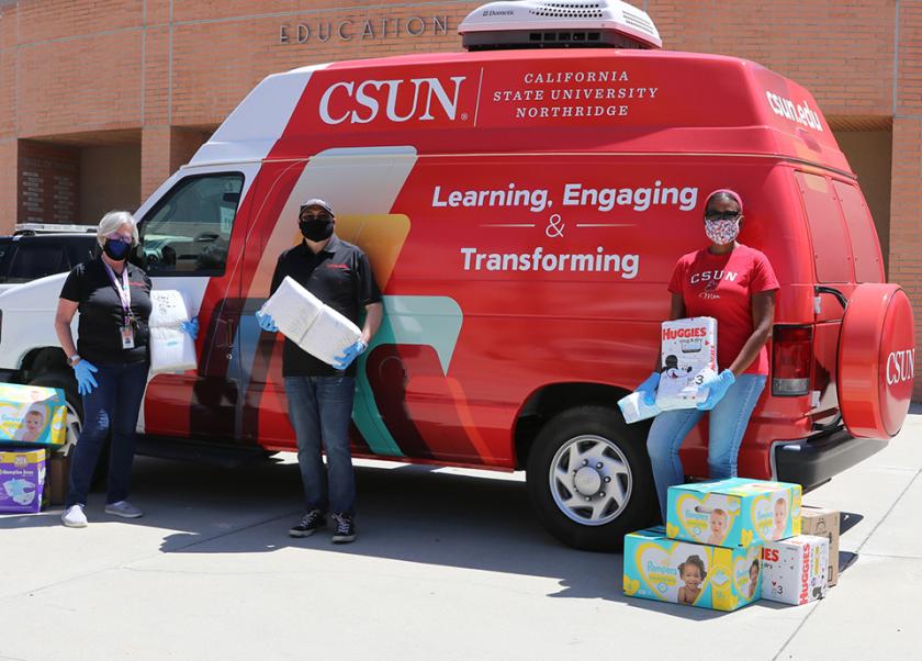 csun van with 3 people holding diapers