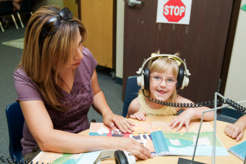 A special education teacher educated at CSU Bakersfield works with a young student.