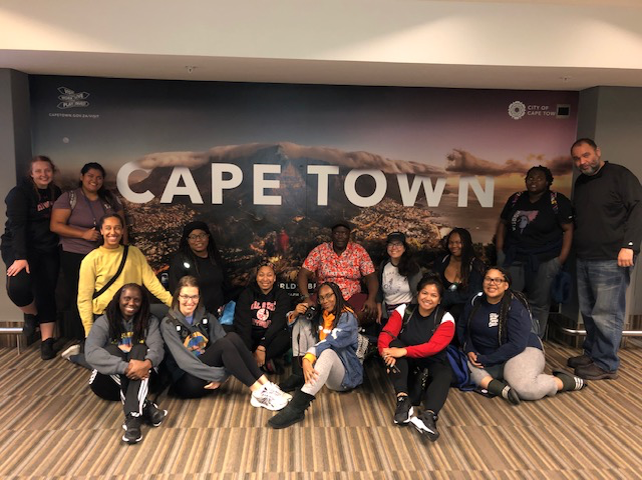 A group of Deaf Studies students and faculty in front of a sign saying &quot;Cape Town&quot;
