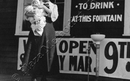 Woman with Baby in front of &quot;You are Welcome&quot; Sign, ca. 1910