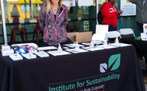 Woman standing behind Institute for Sustainability table