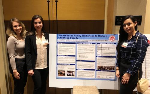 Student interns with research presentation board