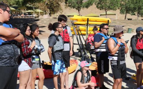 Group picture of Scholars wearing their life jackets as they listen to instructions.