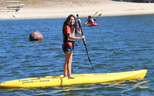 Scholar Melisa Morales paddle boarding on the lake.