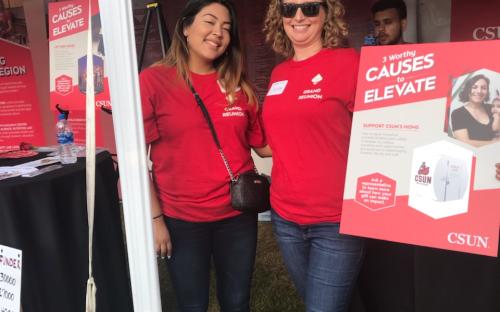 Two women smiling and holding a poster advocating the Mamava Lactation Fundraiser